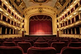 Vue depuis les fauteuils d'orchestre du Théâtre Mogador vers la scène avec balcons dorés et rideaux de velours rouge